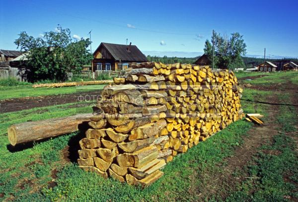 Россия. Сибирь. Красноярский край. Эвенкия. Подкаменная Тунгуска, посёлок Чемдальск, поленница и деревянный дом / Город, архитектура / национальная архитектура